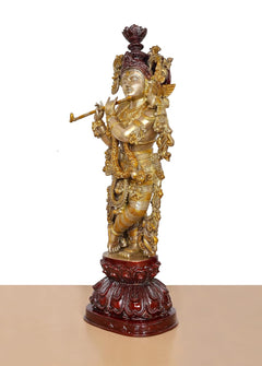 Side view of brass Lord Krishna flute idol with ornate crown and raised hands