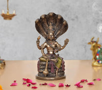 Resin Vishnu seated on Sheshnag statue, raised hands, gold and purple detailing