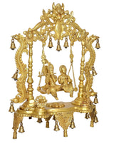 Golden brass Radha Krishna swing idol statue, ornate arch with hanging bell strings