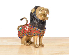 Brass lion sculpture showing profile face, black mane, and multicolored jeweled body