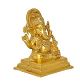 Brass Ganesha statue from rear angle, ornate back halo and raised arm details