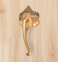 Golden brass Ganesha face door handle with curved lever and arched crown ornament