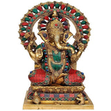 Brass Lord Ganesha idol, detailed headdress, seated on throne with colorful accents