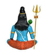 Rear view of seated Shiva murti, blue torso, orange lower cloth, trident at right