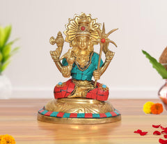 Brass goddess statue, seated with gold headdress, teal top, red patterned skirt, multicolor accents.