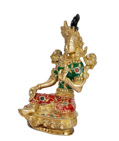Brass Tara Devi statue, side view seated with raised arms, green garment, red skirt