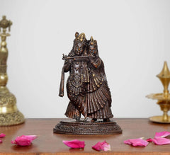 Brass Radha Krishna idol, standing pose, detailed crowns, jewelry, and carved pedestal.