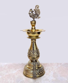 Brass peacock diya oil lamp stand with round base, carved body, and central wick stem