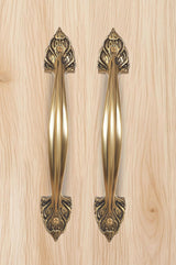 Golden brass door handles pair with ornate top fleur-de-lis escutcheons