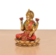 Lakshmi resin figurine seated on lotus base, raised hands holding pink flowers