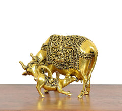 Golden brass cow figurine with calf, side view with filigree trim and small horns