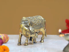 Brass cow with calf statue, close side view, ornate head and leg detailing