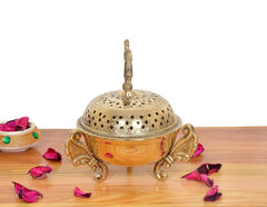 Golden brass loban dhoop dani side view: peacock finial, perforated dome lid