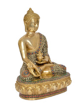 Gold Buddha figurine holding dhyan mudra, jeweled robe detail on side