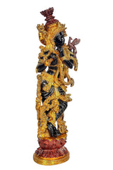 Brass Krishna figurine on ornate base, side view with trident-like ornament