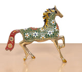 Brass running horse figurine low angle, ornate green saddle with red side panel