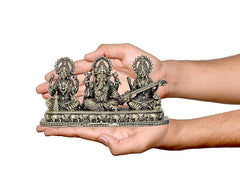 Brass Ganesha Lakshmi Saraswati showpiece held in hands for size scale
