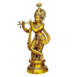 Brass Krishna statue with ornate crown, right hand raised holding flute, on base