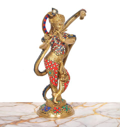 Rear three-quarter view of brass Krishna flute sculpture, blue patterned robe and red accents.