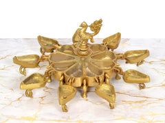 Top view of golden brass kumkum box with peacock finial and 9 compartments