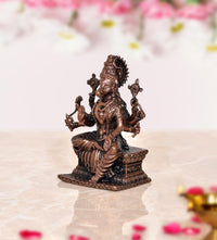Copper Varahi deity sculpture seated on base, multiple arms holding small objects, 3 in