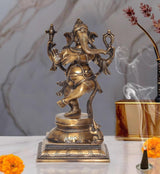 Gold-toned dancing Ganesha brass statue with ornate arms and festival-style pose