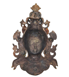 Back view of Tara wall hanging mask statue, dark metal finish with ornamental arms