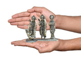 Hand holding Ram Darbar bronze statue set, three standing figures with detailed crowns