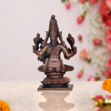 Copper Vishnu avatar rear view, seated multi-armed idol with tall headpiece