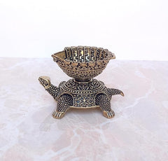 Ornate brass tortoise diya oil lamp, front view with decorative bowl