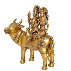 Brass Shiva family idol riding Nandi, close side view with trident and figures