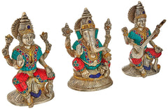 Lakshmi, Ganesha, Saraswati brass idols, silver tone, teal-and-red detailing, raised arms
