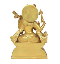 Back view of golden brass Saraswati statue with large circular halo and lotus base