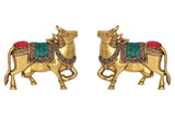 Brass cow pair wall hanging, both figures facing forward, red and green accents
