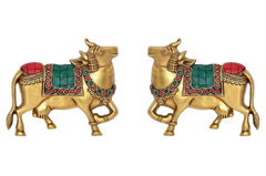 Brass cow pair wall hanging, both figures facing forward, red and green accents