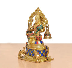 Brass Lakshmi statue side view with multicolored beadwork, crown, and hanging bells