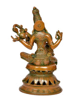 Back view of brass Saraswati statue with veena and ornate headdress, seated on base