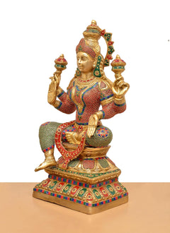 Lakshmi brass idol side view, four arms in blessing gestures, lotus base