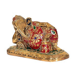 Side view of lying brass Ganesha statue, red enamel with colorful gemstone accents