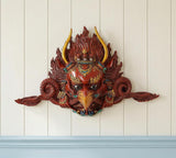 Resin Garuda face wall hanging mask with red features, gold horns, and teal accents