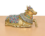Seated Nandi brass figurine with raised tail and multicolor gemstone-style decorations