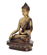 Side view of brass Buddha statue sitting in meditation, dhyan mudra, on ornate dark base