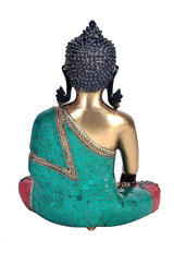Back view of brass Buddha statue, turquoise draped shawl with red patterned seat