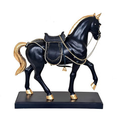 Front view of black horse statue with golden mane, decorated saddle, reins and chain accents.