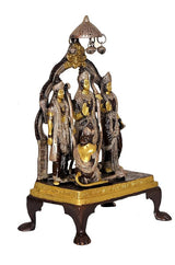 Brass Ram Darbar statue with bowed devotees, central figure under hanging lamps, side view