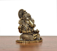 Superfine Brass Ganesha idol, angled view, ornate crown and torso details, 2-inch height.