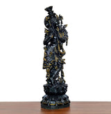 Lord Krishna brass figurine, side view, playing flute, ornate dark surface with gold accents