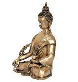 Brass Buddha statue in side view, seated with raised hand and floral ornament