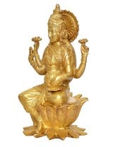 Brass Lakshmi idol side view with raised hands and detailed crown, seated on lotus