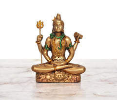 Seated four-armed Shiva idol, gold resin with green necklace and raised hand tools